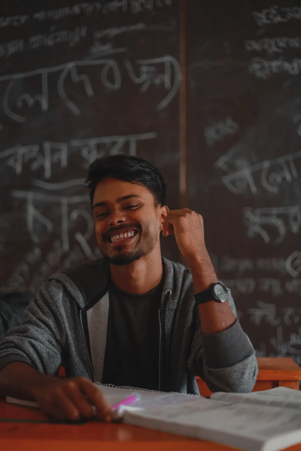 A smiling tutor at a classroom chalkboard