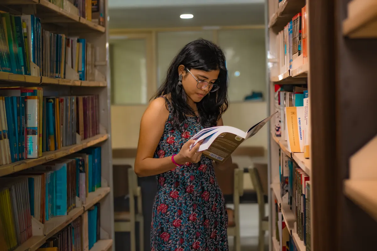 A tutor reading through study material in a library