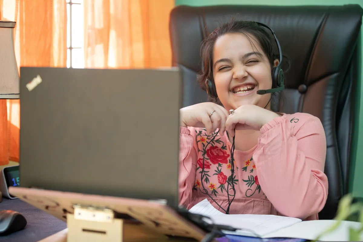A smiling girl with a headset during a live online lesson